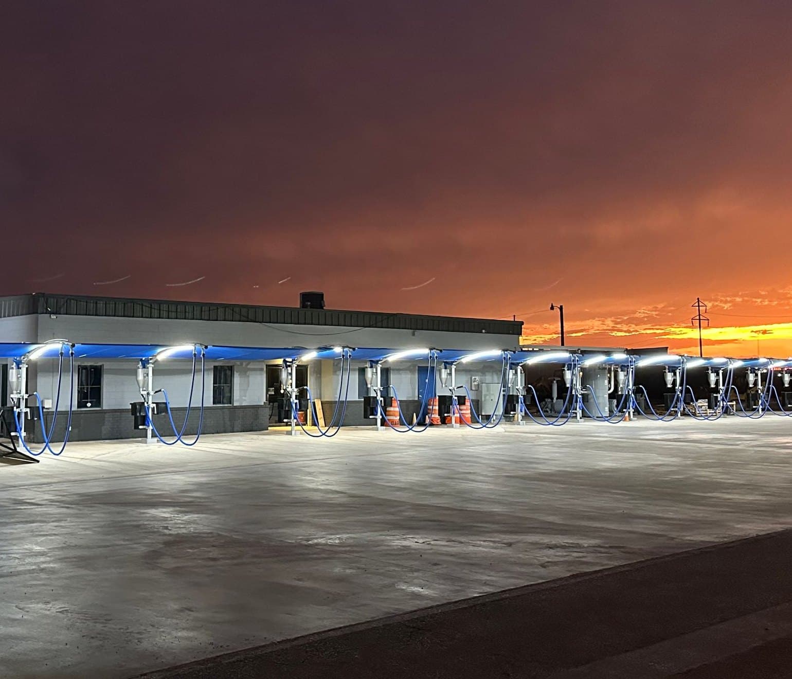 Shine Brite Express Wash at dusk, the blue vacuum canopy lit up under an orange West Texas sky
